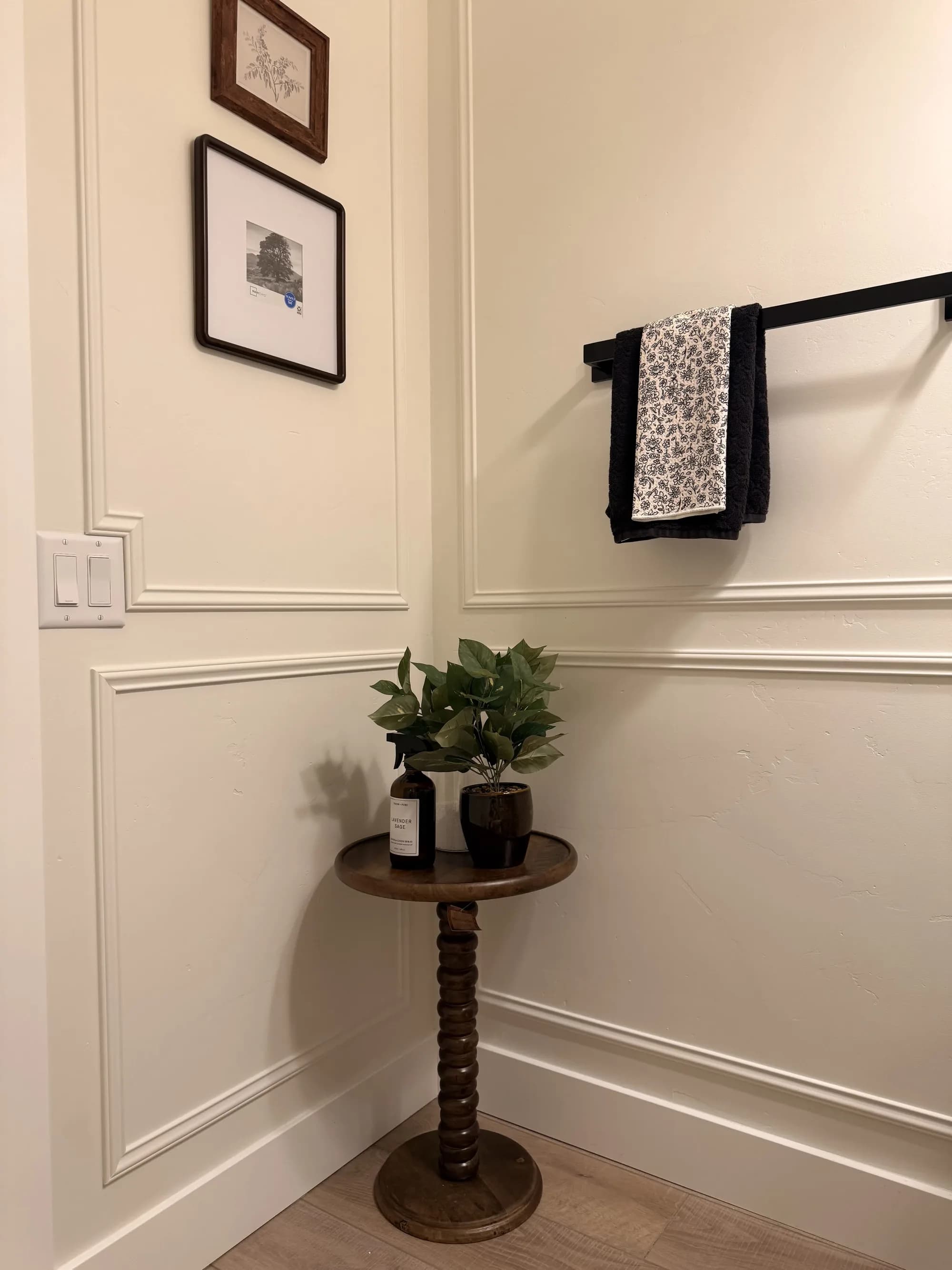 Corner with white panel molding, framed art, and toile towel by BK Toolbox