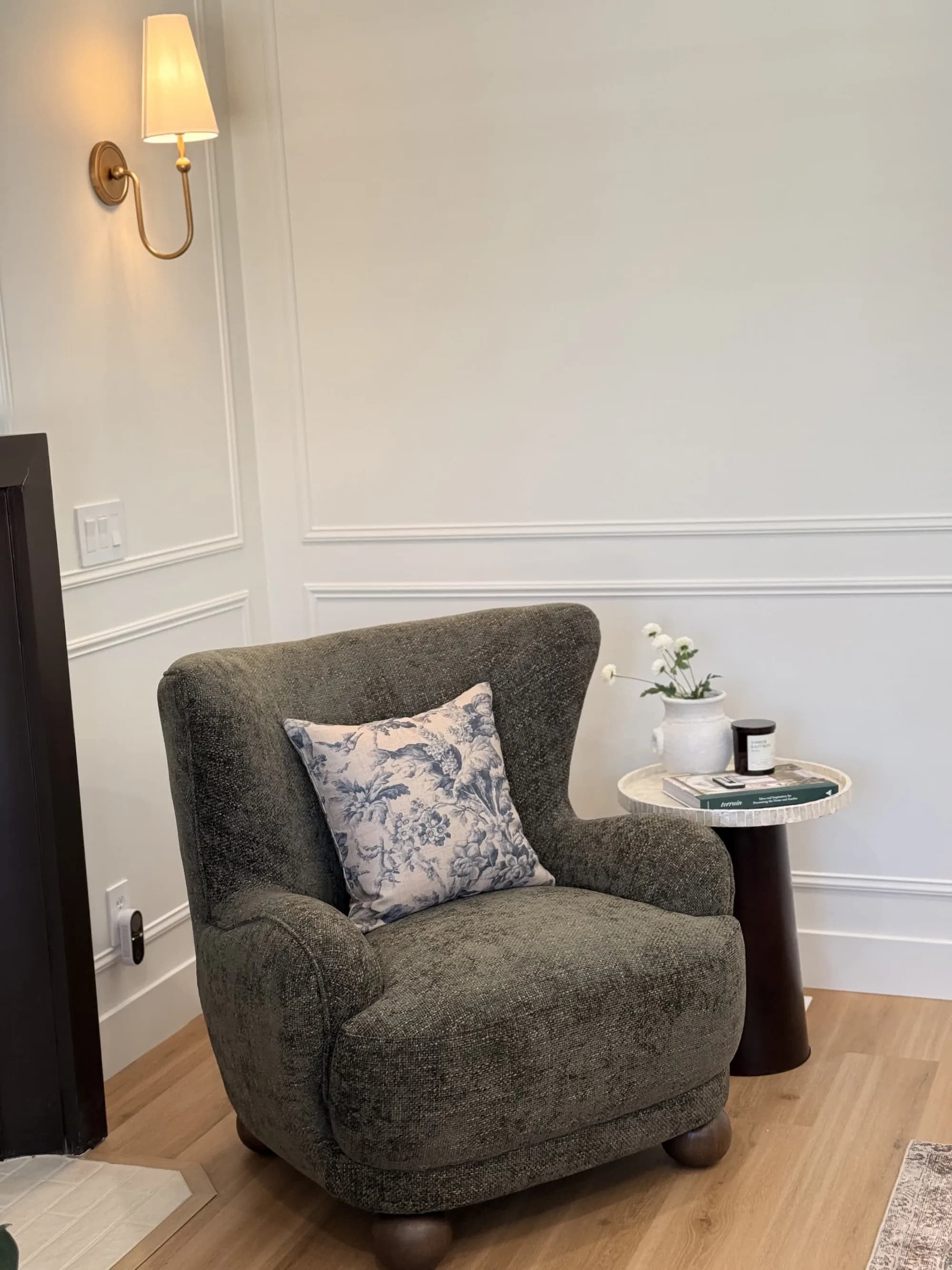 Reading nook with green wingback chair, toile pillow, and panel molding by BK Toolbox