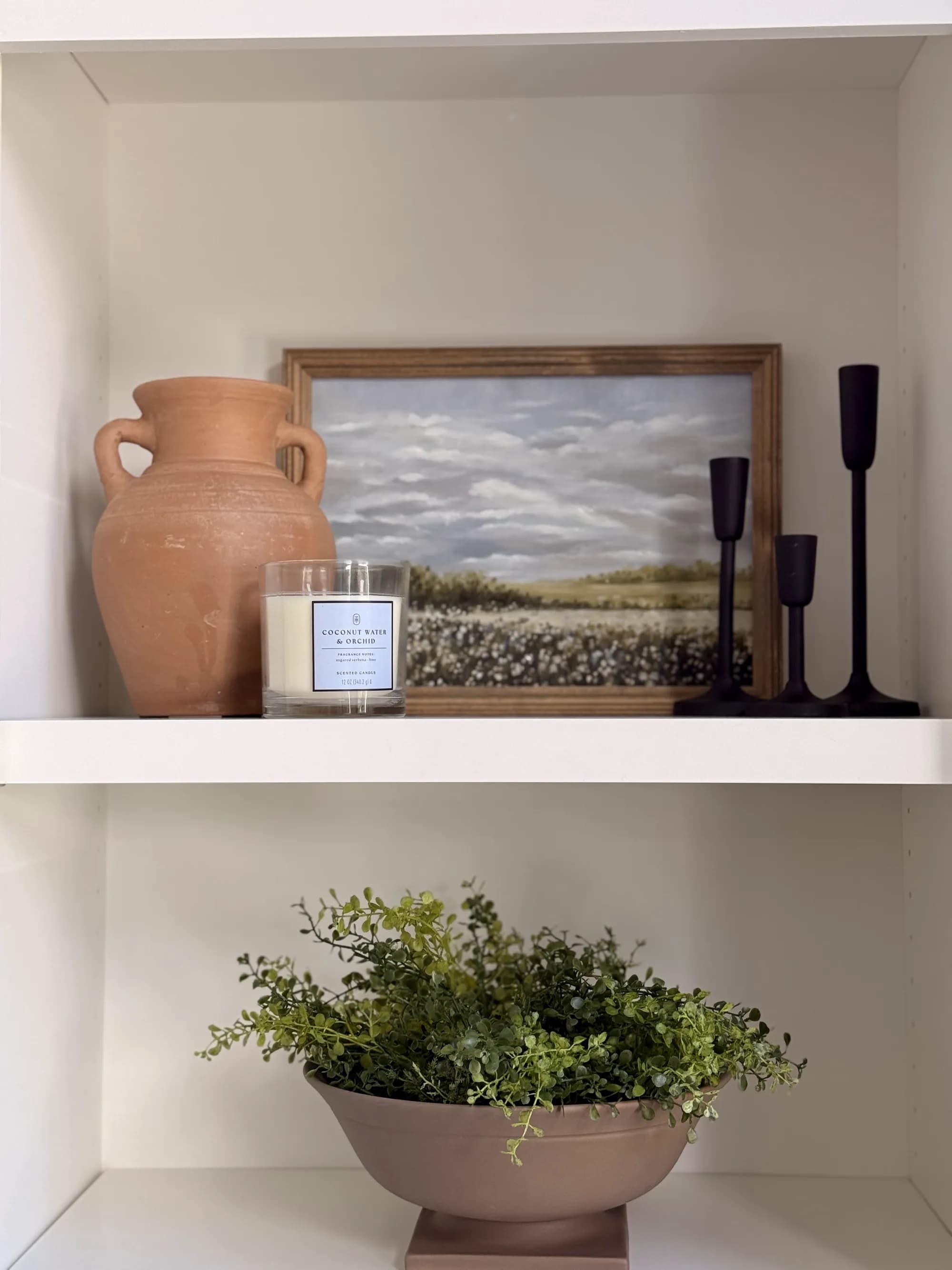 Styled shelf with terracotta vase, landscape art, and candle by BK Toolbox