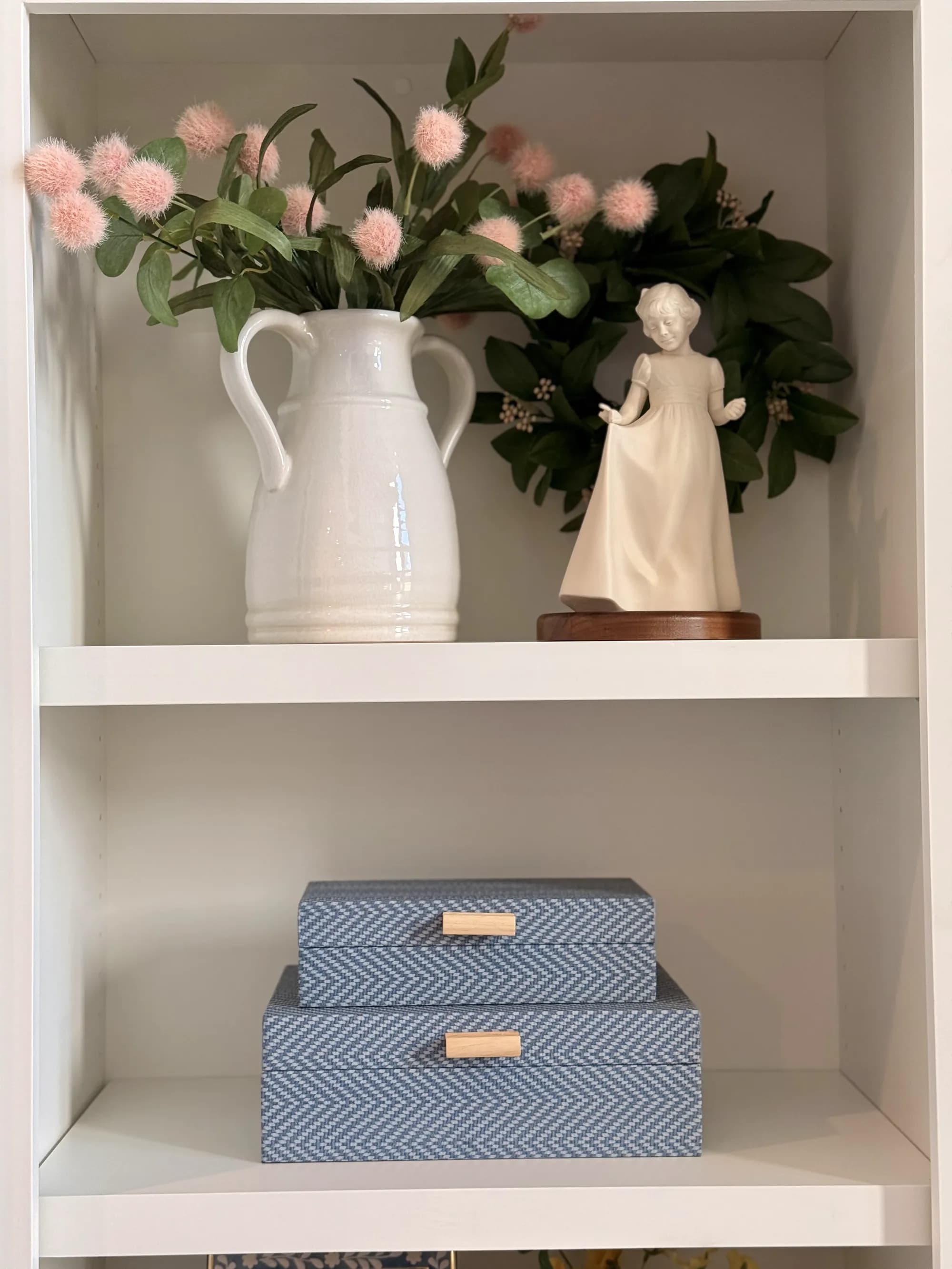 Styled shelf with white pitcher, figurine, and patterned boxes by BK Toolbox