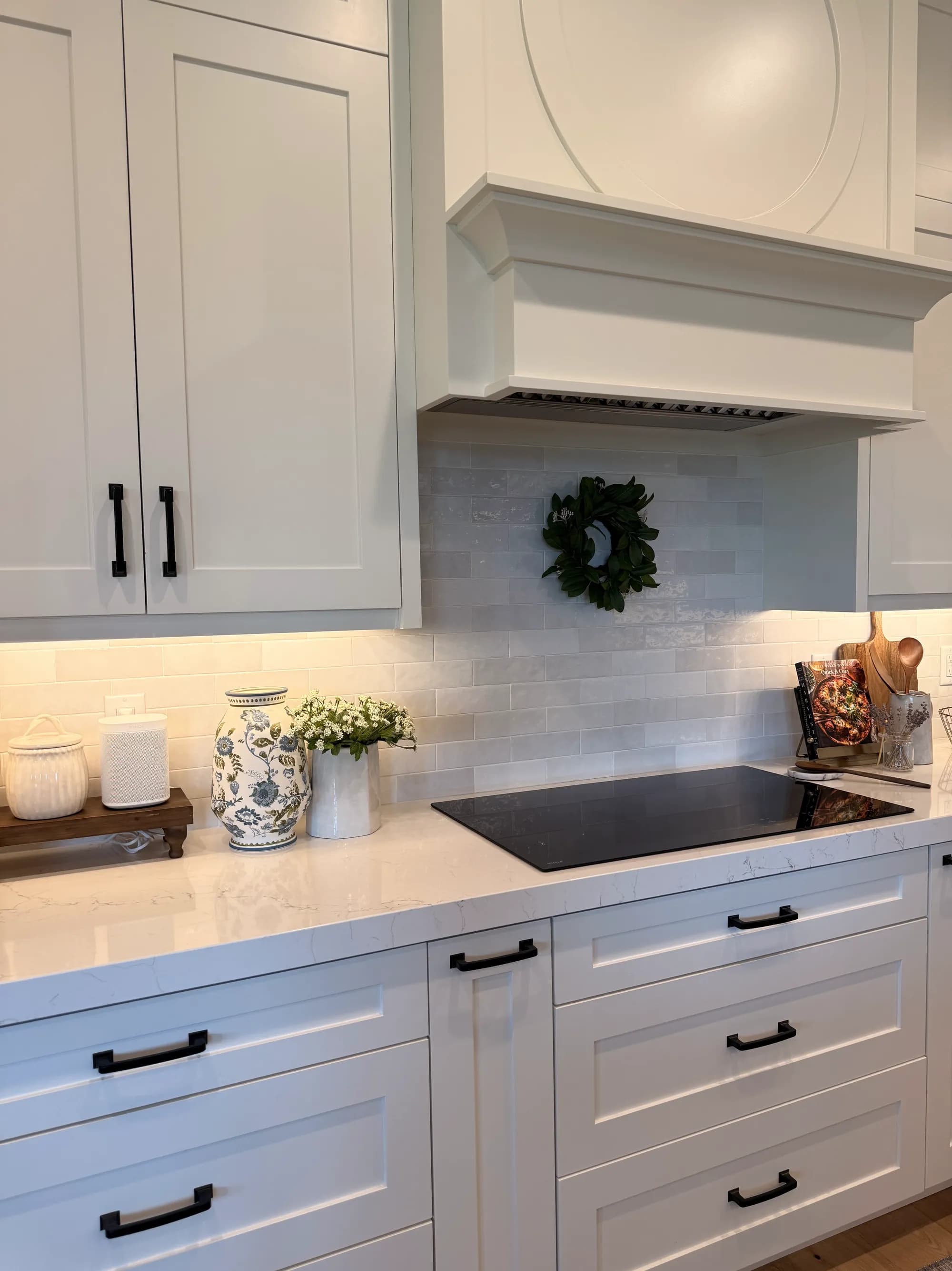 White kitchen with shiplap range hood, tile backsplash, and styled counters by BK Toolbox